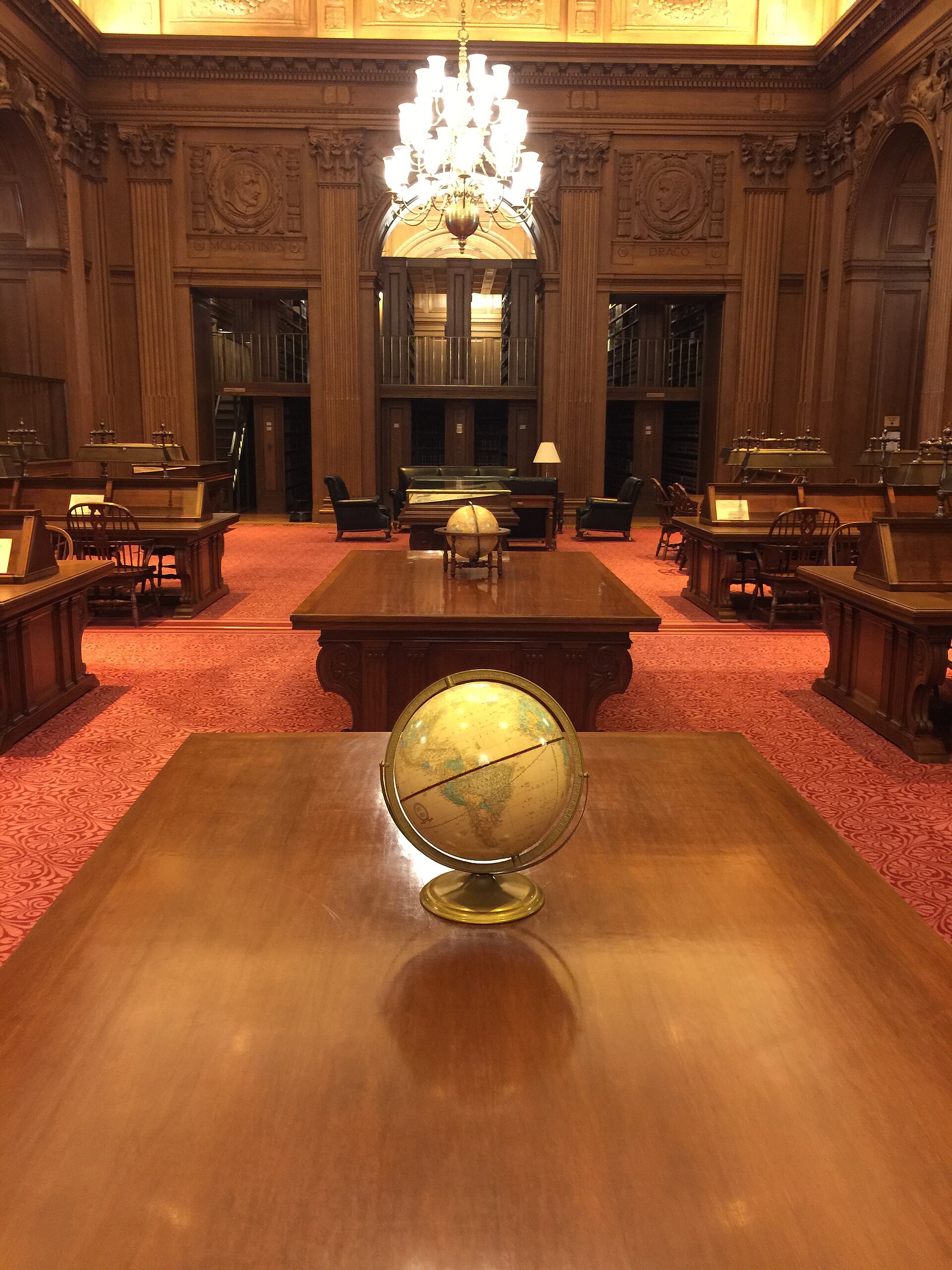 A reading room in the library of the Supreme Court of the United States, with a globe and reading tables beneath a carved and gilded ceiling.